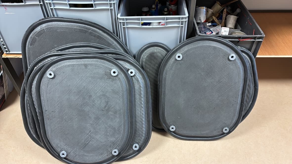 Stack of oval carbon hatches with sealing gaskets and mounting inserts